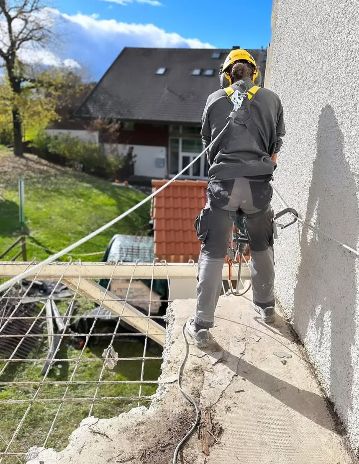 Travaux en hauteur avec harnais sur la dalle en encorbellement et armatures apparentes