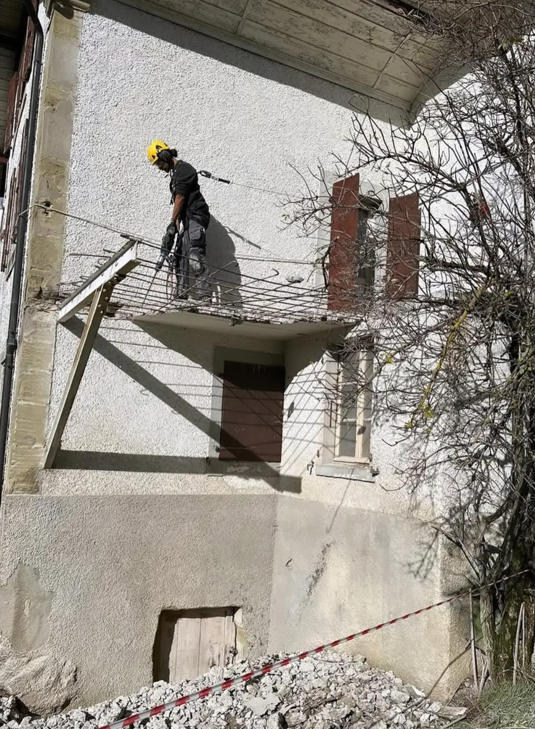 Démolition de l’ancien balcon au marteau, armatures dégagées
